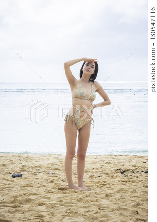 穿著泳衣看海的年輕女子 130547116