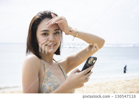 穿著泳衣看海的年輕女子 130547118