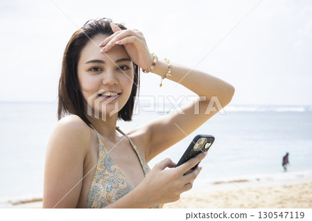 Young woman in a swimsuit looking at the sea Young woman in a swimsuit looking at the sea 130547119