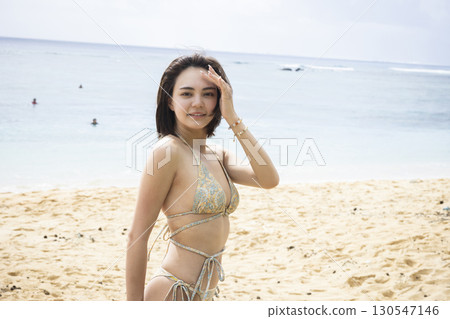 一位穿著泳衣的女子正在享受大海 130547146