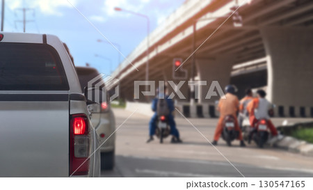 Rear side of pickup car with turn on brake light. Stop on the road by traffic red control in the junction. Stop with together other car and motorcycle. Under concrete bridge level. Evironment at day. Rear side of pickup car with turn on brake light. Stop on the road by traffic red control in the junction. Stop with together other car and motorcycle. Under concrete bridge level. Evironment at day. 130547165