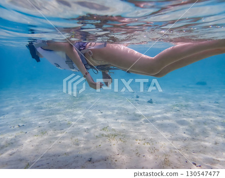 A woman in a swimsuit enjoying the sea 130547477
