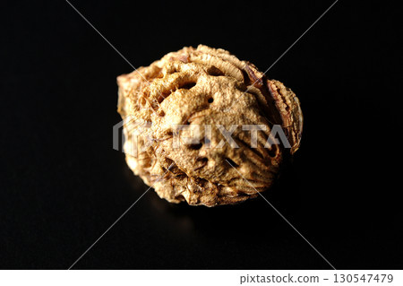 Peach seeds photographed against a black background Peach seeds photographed against a black background 130547479