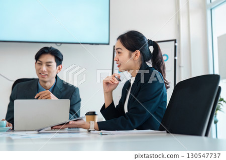 Collaborative business discussion between professionals in a meeting setting. 130547737