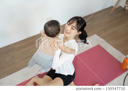 Joyful mother lifting her baby in a playful indoor moment Joyful mother lifting her baby in a playful indoor moment 130547738