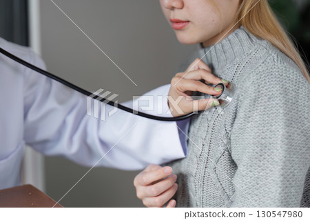 Caring Muslim female doctor using a stethoscope to examine a patient in a modern healthcare setting, highlighting diversity in medicine. Caring Muslim female doctor using a stethoscope to examine a patient in a modern healthcare setting, highlighting diversity in medicine. 130547980