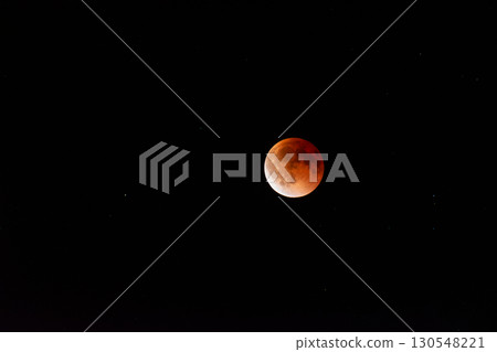 Breathtaking Blood Moon During a Total Lunar Eclipse Against a Starry Sky 130548221