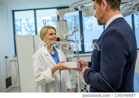 Doctor and pharmaceutical representative talking about new drug, clinical setting. 130549897