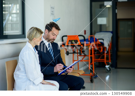 Pharmaceutical sales representative introducing new medication to female doctor. 130549908