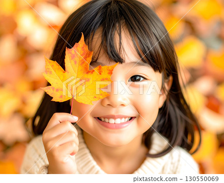 Girl holding fallen leaves 130550069