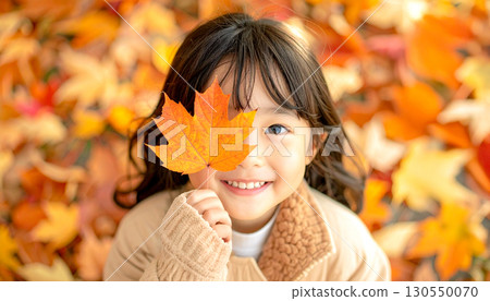 Girl holding fallen leaves 130550070