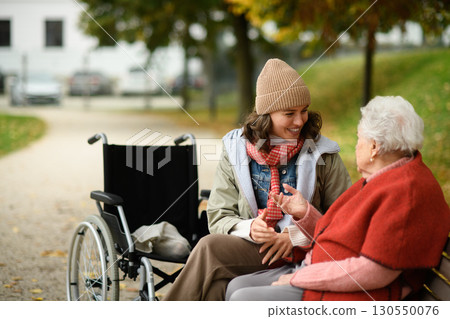 Granddaughter talking grandmother in autumn park. Granddaughter talking grandmother in autumn park. 130550076