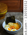 Shrimp ramen with boiled egg, corn, and nori. A delicious and savory Asian noodle soup, perfect for a hearty meal. 130550352