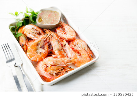 Grilled shrimps with spicy sauce in a white tray. Grilled shrimps with spicy sauce in a white tray. 130550425