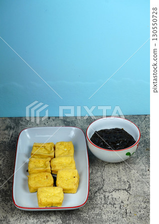 Tahu goreng or Fried tofu with petis or black shrimp paste dipping sauce, a popular Indonesian snack from Surabaya, East Java. 130550728
