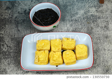 Tahu goreng or Fried tofu with petis or black shrimp paste dipping sauce, a popular Indonesian snack from Surabaya, East Java. 130550730
