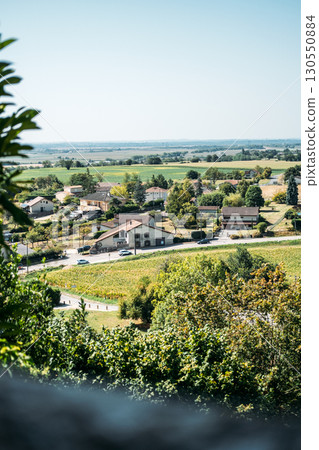 Scenic view of a rural French village surrounded by farmland and greenery under a clear sky. Return to the countryside, neo-ruralism, remote work migration, slow living 130550884