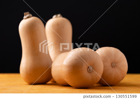 Fresh butternut squash pumpkin on orange and black background 130551599