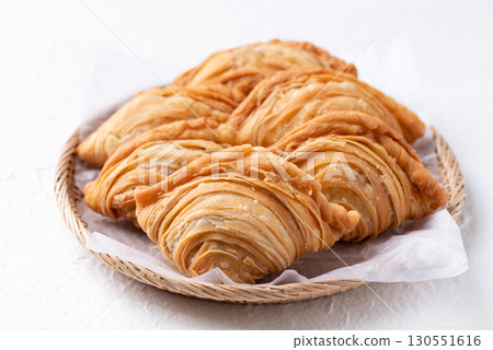 Thai Curry puff stuffed with chicken or sweet potatoes in basket on white background 130551616