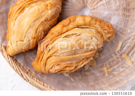 Top view of curry puff stuffed with chicken or sweet potatoes in basket, Thai snack food style 130551619