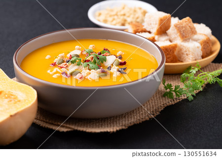 Butternut squash pumpkin soup in a bowl on black background, Homemade food in autumn season 130551634