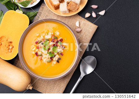 Butternut squash pumpkin soup in a bowl on black background, Homemade food in autumn season Butternut squash pumpkin soup in a bowl on black background, Homemade food in autumn season 130551642