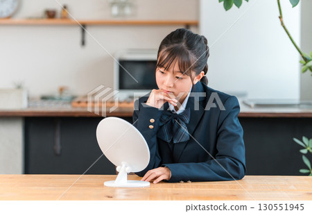 A girl in a uniform looking depressed in the mirror in the living room of her home (complex, trouble) A girl in a uniform looking depressed in the mirror in the living room of her home (complex, trouble) 130551945