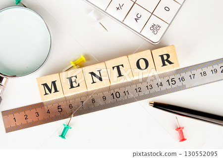 The MENTOR concept word is assembled from wooden cubes on a white surface. The concept of business and development 130552095
