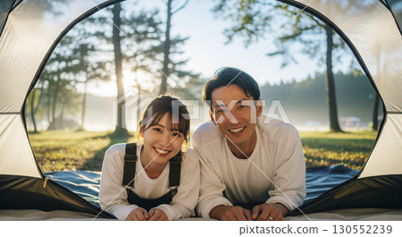 A couple lying down in a tent at a campsite 130552239