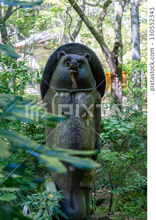 Tanuki statue surrounded by greenery at Mitaki-Dera in Hiroshima 130552343
