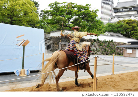 A warrior shooting an arrow during Yabusame A warrior shooting an arrow during Yabusame 130552472