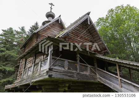 A historic wooden church featuring unique architecture amidst a tranquil forest 130553106