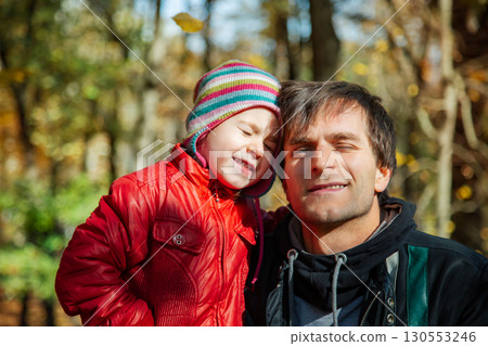 Father daughter sharing joyful moment autumn park. Family bonding seasonal happiness concept Father daughter sharing joyful moment autumn park. Family bonding seasonal happiness concept 130553246