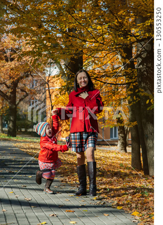Mother and daughter enjoying sunny autumn day in park. Family togetherness and fall leisure concept 130553250