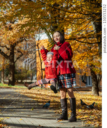 Mother and daughter enjoying sunny autumn day in park. Family togetherness and fall leisure concept 130553252