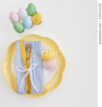 Happy Easter. Easter celebration concept. Top view vertical empty white and yellow plate, Easter egg 130553270