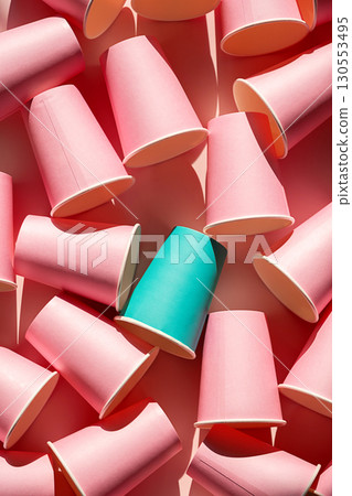 Teal paper cup standing out among many pink paper cups. Individuality and diversity concept. 130553495