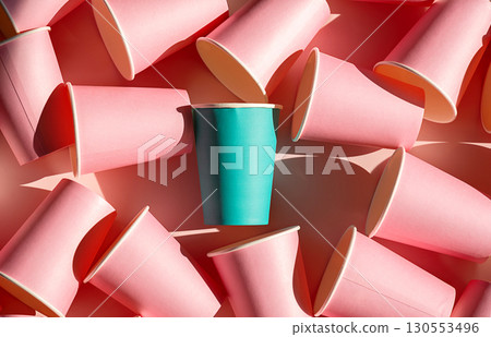 Teal paper cup stands out among many pink paper cups. Individuality and uniqueness concept 130553496