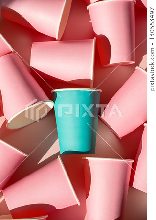 Teal paper cup standing out among many pink cups. 130553497