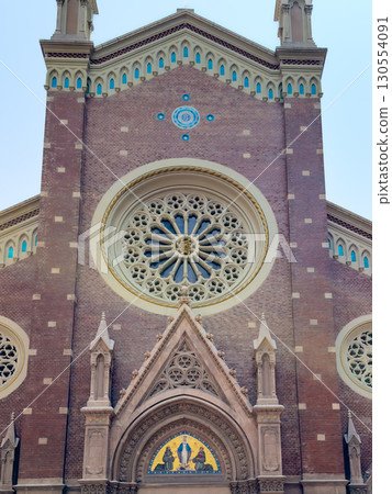 The facade of a beautiful historic church with a rosette window The facade of a beautiful historic church with a rosette window 130554091