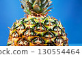 Closeup shot of a pineapple on a bright blue background 130554464