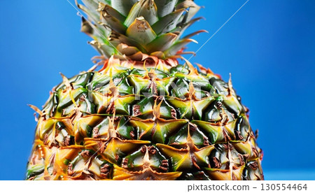 Closeup shot of a pineapple on a bright blue background 130554464