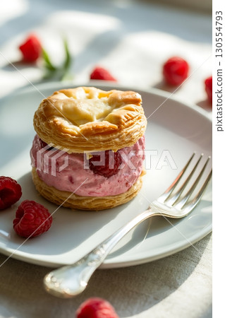 Flaky Puff Pastry with Raspberry Cream Filling and Fresh Raspberries on a Plate 130554793