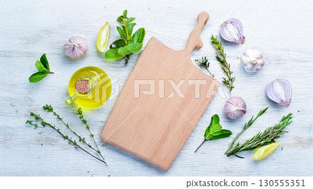 木製切菜板周圍環繞著橄欖油和香草 130555351