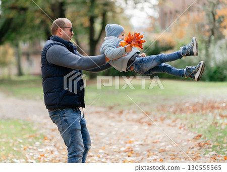 Father and child playing together in nature. Symbol of trust, fun, family connection 130555565