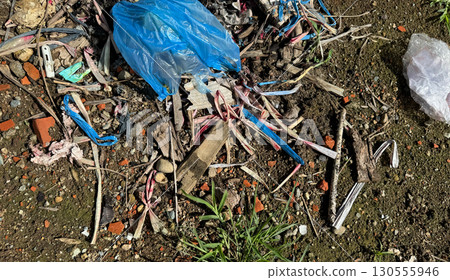 Plastic waste and scattered trash on soil surface 130555946