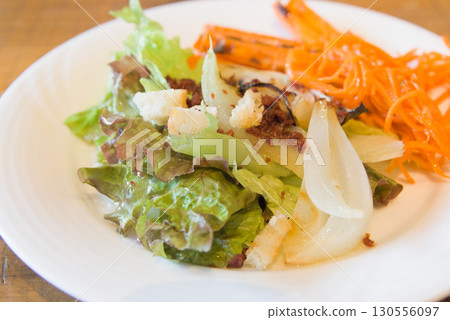 Lettuce and carrot salad served on a white plate 130556097