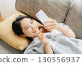 躺在沙發上使用智能手機的女人 130556937