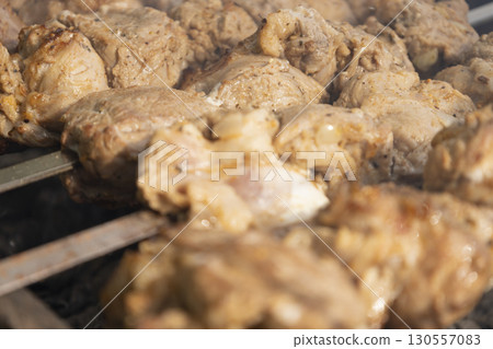Juicy slices of meat prepare on the fire. Tasty shish kebab on skewers. Grilled marinated barbecue meat - shashlik on pork Juicy slices of meat prepare on the fire. Tasty shish kebab on skewers. Grilled marinated barbecue meat - shashlik on pork 130557083