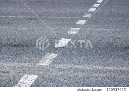 This image shows a closeup of a road with visible white lines This image shows a closeup of a road with visible white lines 130557625